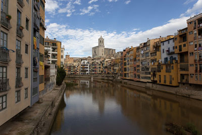 Canal amidst buildings in city, , girona spain