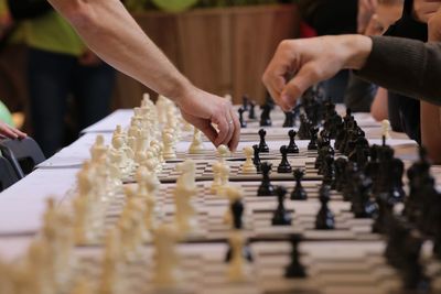 Cropped image of friends playing chess