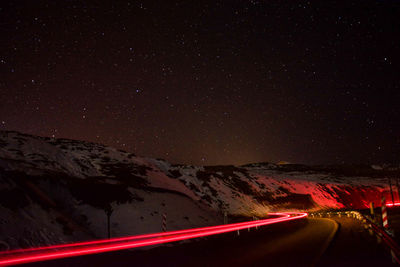 Aerial view of snowcapped mountain against sky at night
