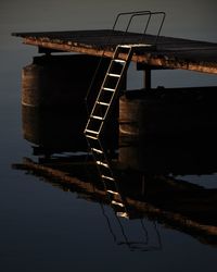 Bridge over river against sky at sunset