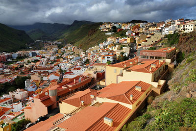 Residential district on mountain at san sebastian de la gomera against cloudy sky