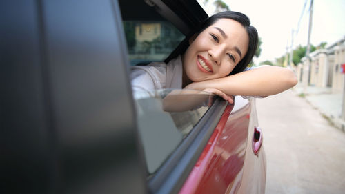 Portrait of happy young woman in car