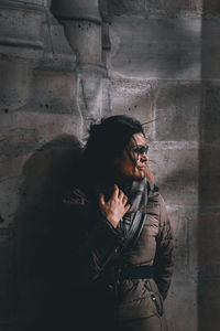 Woman standing against wall in building