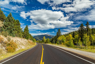 Road amidst trees against sky