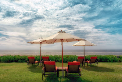 Chairs on beach against sky