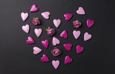 High angle view of pink heart shape on table against black background