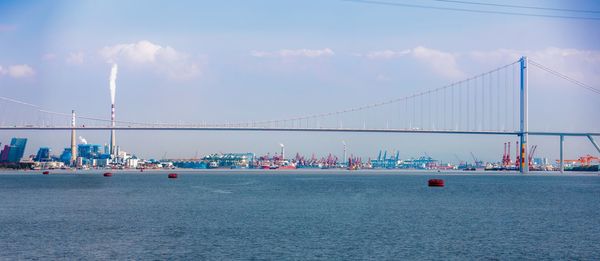 View of suspension bridge against cloudy sky