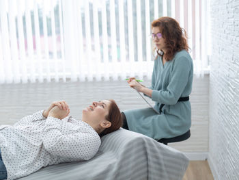 Female doctor examining patient at home