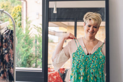 Mature woman choosing dress at store