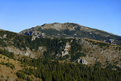 Scenic view of rocky mountains against clear blue sky