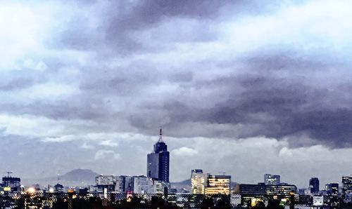 View of cityscape against cloudy sky