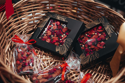 Handmade dark chocolate packaging mockup with dry berries in a wicker basket. tasty food.