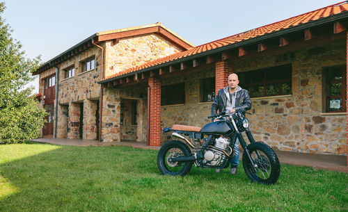 Young man posing with a custom motorbike outdoors