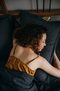 Woman sleeping on her stomach on bed at home