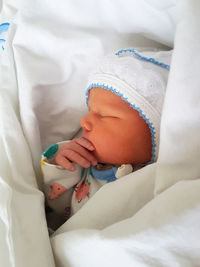 Close-up of baby girl on bed at hospital