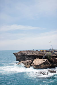 Rocks by sea against sky