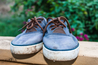 Close-up of canvas shoes on retaining wall