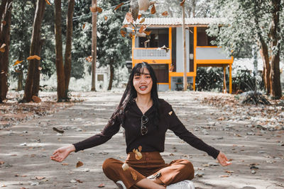 Portrait of smiling young woman sitting outdoors