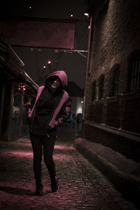 Full length portrait of woman standing at night