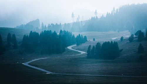 Scenic view of road by mountains against sky