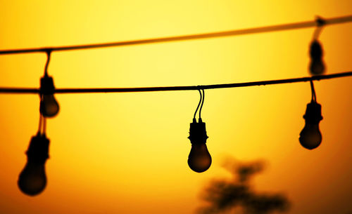 Low angle view of light bulb against sky during sunset