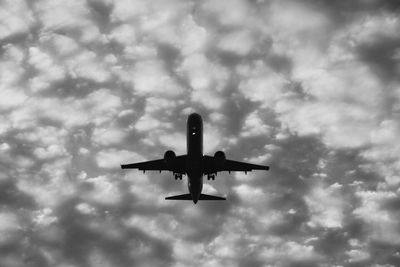 Low angle view of airplane flying against sky