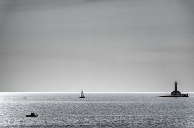 Sailboat in sea against clear sky