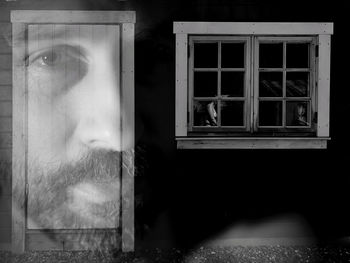 Portrait of man looking through glass window of building