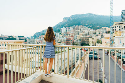 Rear view of woman with umbrella against sky