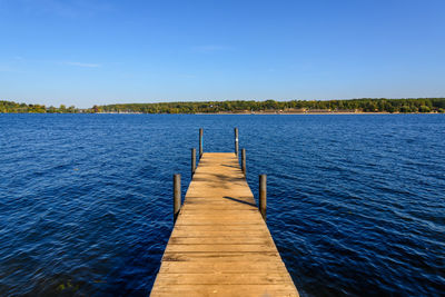 View from long wooden pier onto wannsee lake and havel river in autumn in berlin, germany.
