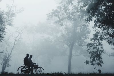 Side view of man riding bicycle against sky