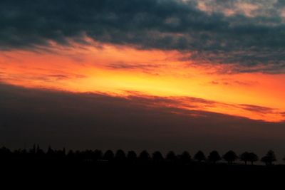 Scenic view of silhouette landscape against orange sky