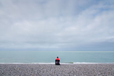 Rear view of girl looking at sea against sky