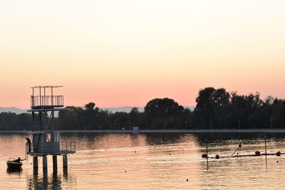 Scenic view of lake against clear sky during sunset