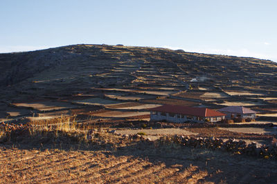 Scenic view of field by buildings against sky