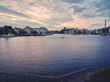 Scenic view of river by buildings against sky