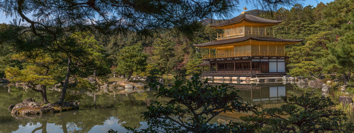 Panoramic view of a temple in the woods with reflection in calm waters