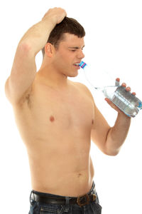 Midsection of shirtless man standing against white background