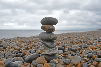 Stack of pebbles on beach against sky