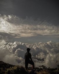 Rear view of man standing on landscape against sky