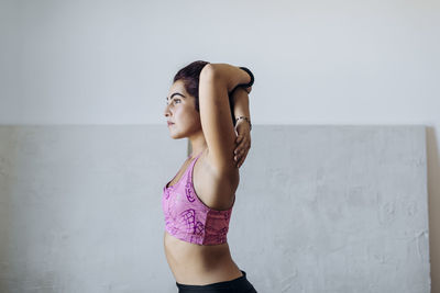 Slim hispanic woman doing yoga stretch exercise