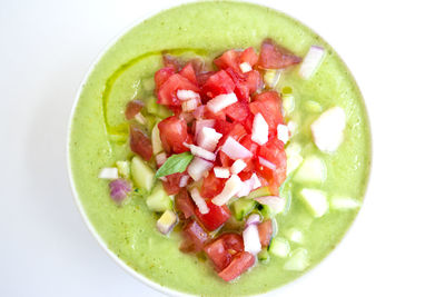 Close-up of chopped fruits in bowl against white background