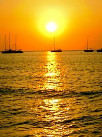 Boats sailing in sea during sunset