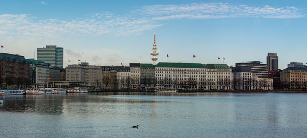 View of buildings in city against cloudy sky