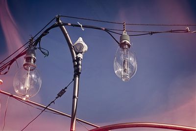 Low angle view of illuminated light bulb against sky