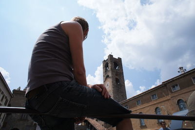 Low angle view of woman standing against wall