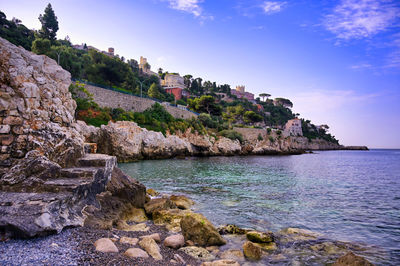 Rock formations by sea against sky