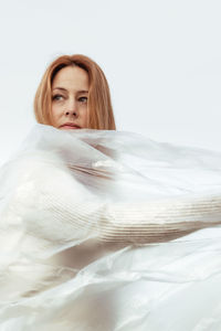 Portrait of young woman lying on bed