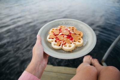 Cropped hand of woman holding food