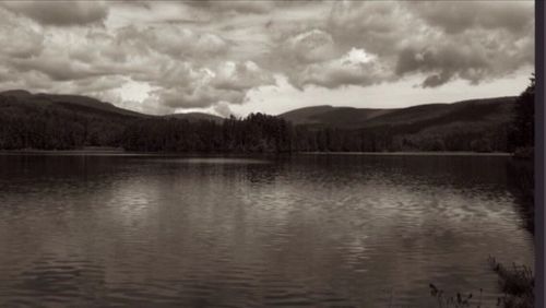 Scenic view of lake against cloudy sky